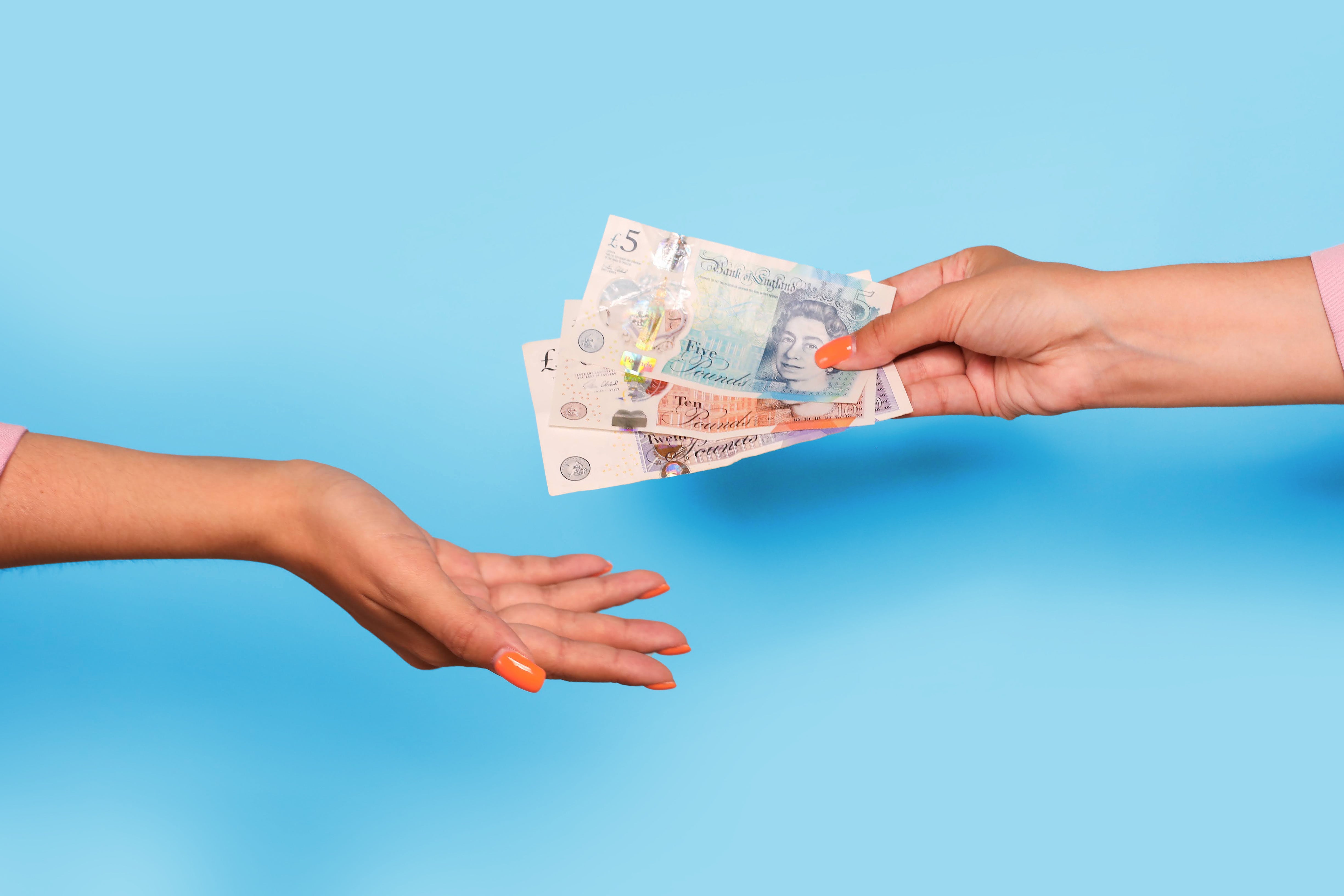 Buyer handing customer over UK notes to seller